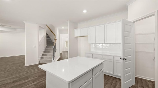1149 Blue Juniper Cir, Loganville, GA 30052 - kitchen with a center island, dark wood-style floors, tasteful backsplash, white cabinetry, and light countertops