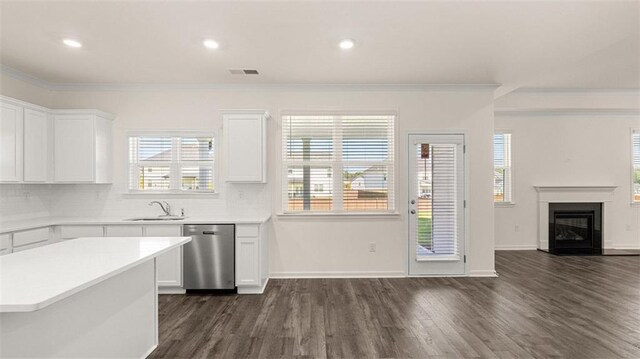 1149 Blue Juniper Cir, Loganville, GA 30052 - kitchen featuring stainless steel dishwasher, ornamental molding, open floor plan, dark wood-style flooring, and white cabinetry