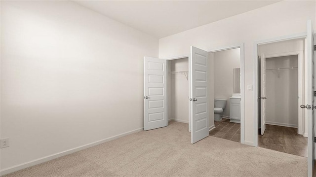 1149 Blue Juniper Cir, Loganville, GA 30052 - unfurnished bedroom with carpet floors, two closets, baseboards, and ensuite bath