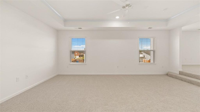 1149 Blue Juniper Cir, Loganville, GA 30052 - spare room with a tray ceiling, light carpet, a ceiling fan, and baseboards