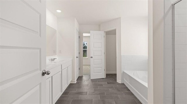 1149 Blue Juniper Cir, Loganville, GA 30052 - bathroom with a bath, vanity, recessed lighting, and wood finish floors