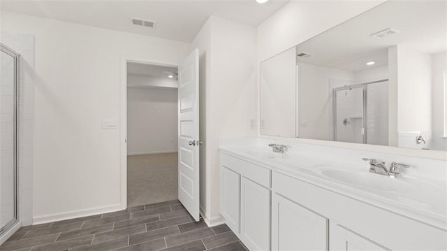 1149 Blue Juniper Cir, Loganville, GA 30052 - bathroom with double vanity, a shower with door, wood tiled floors, recessed lighting, and baseboards