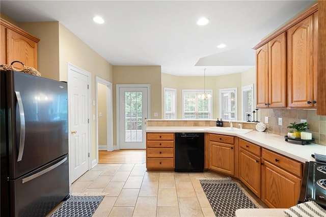 223 Oak Grove Dr, Dallas, GA 30157 - kitchen featuring freestanding refrigerator, black dishwasher, a sink, tasteful backsplash, and light countertops