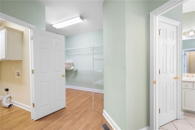 223 Oak Grove Dr, Dallas, GA 30157 - washroom featuring washer hookup, light wood-style flooring, baseboards, and cabinet space