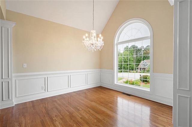 223 Oak Grove Dr, Dallas, GA 30157 - empty room featuring wood finished floors, a wainscoted wall, a chandelier, and vaulted ceiling