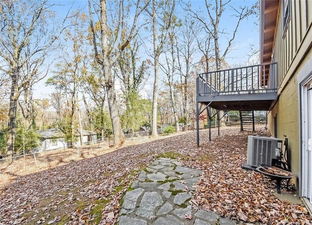 view of yard with central AC unit and a wooden deck