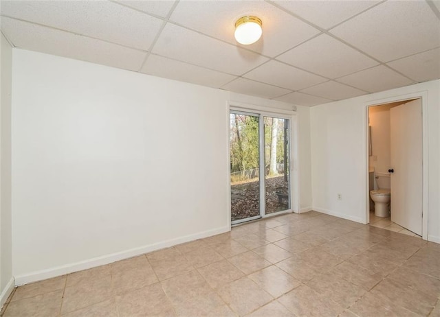 tiled empty room with a drop ceiling