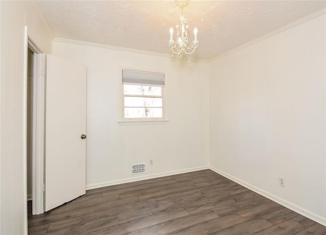 empty room with a chandelier, dark hardwood / wood-style flooring, and ornamental molding