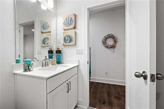 bathroom featuring vanity, wood finished floors, and baseboards