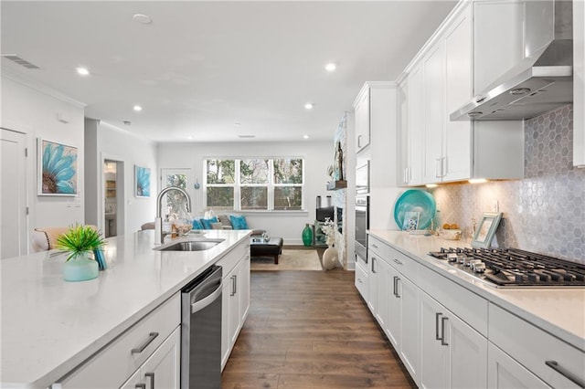 kitchen featuring a sink, white cabinetry, stainless steel appliances, wall chimney exhaust hood, and light countertops