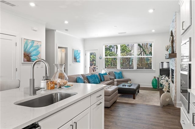 kitchen featuring recessed lighting, white cabinetry, dark wood-type flooring, and a sink