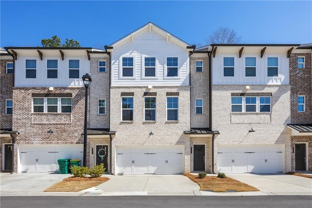 townhome / multi-family property with an attached garage, brick siding, board and batten siding, and driveway