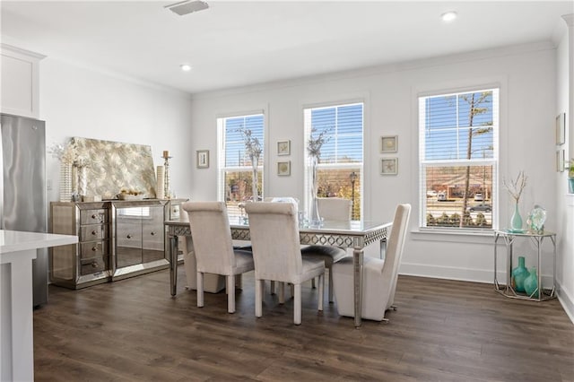 dining space with a wealth of natural light, dark wood-style floors, visible vents, and ornamental molding