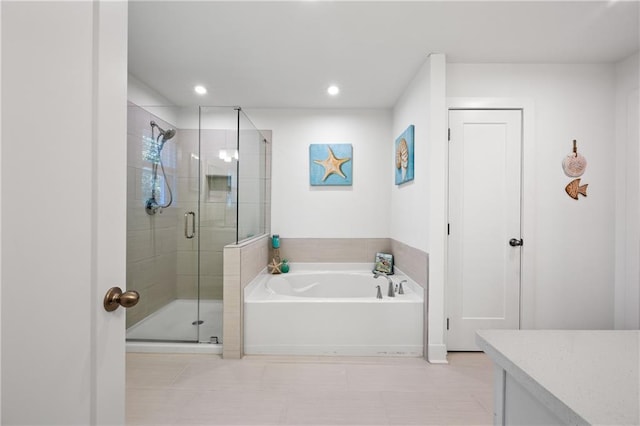 bathroom featuring recessed lighting, a shower stall, vanity, and a garden tub