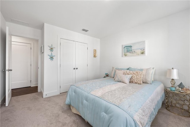 carpeted bedroom featuring baseboards and a closet