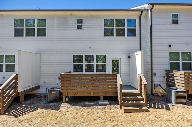 rear view of property featuring central air condition unit and a wooden deck