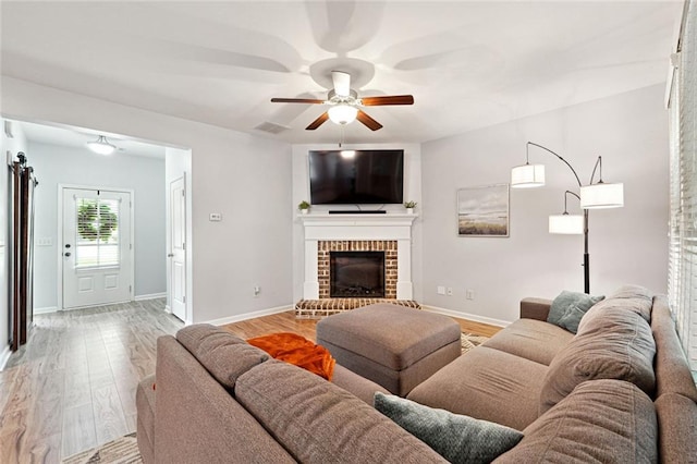 5925 Watersdown Way, Flowery Branch, GA 30542 - living room with ceiling fan, light wood finished floors, baseboards, and a fireplace