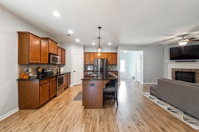 kitchen featuring stainless steel appliances, dark countertops, baseboards, decorative backsplash, and open floor plan