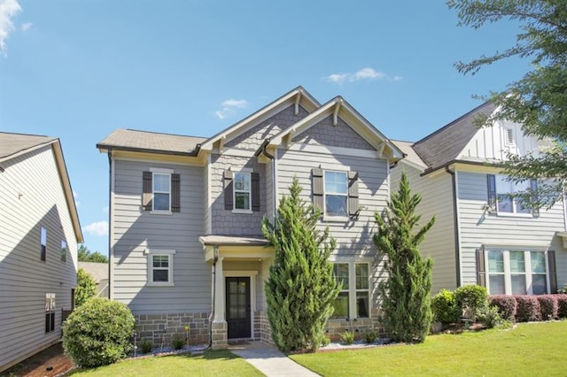 view of front of house featuring stone siding and a front yard