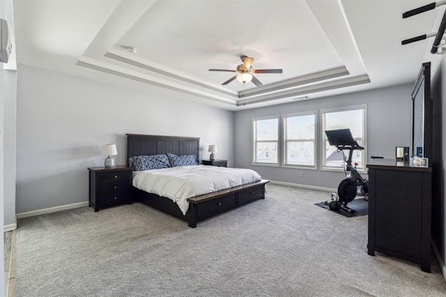 bedroom with baseboards, carpet floors, and a raised ceiling