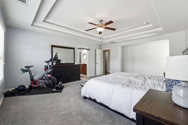 bedroom with light carpet, a tray ceiling, visible vents, baseboards, and crown molding