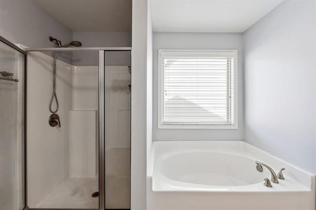 bathroom featuring a shower stall and a garden tub