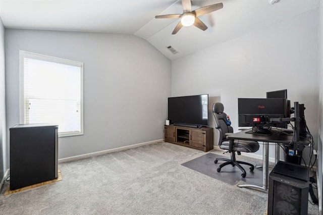 carpeted office with vaulted ceiling, visible vents, baseboards, and ceiling fan