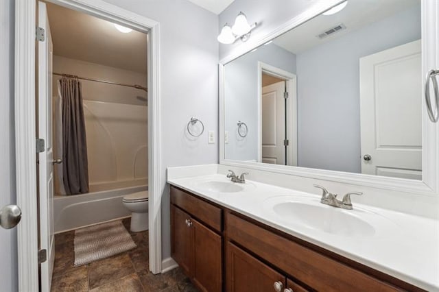 bathroom with visible vents, a sink, double vanity, and toilet