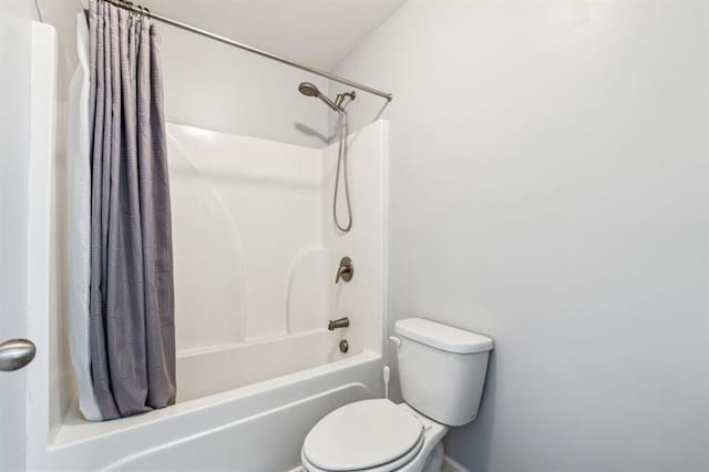bathroom featuring shower / tub combo and toilet