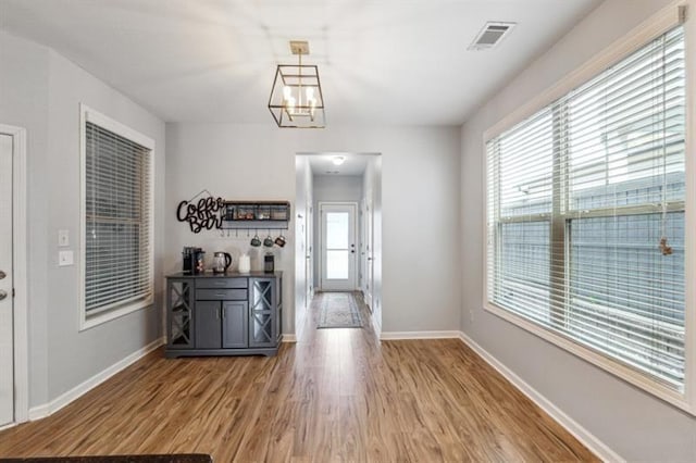 5925 Watersdown Way, Flowery Branch, GA 30542 - unfurnished dining area featuring wood finished floors, baseboards, and a chandelier