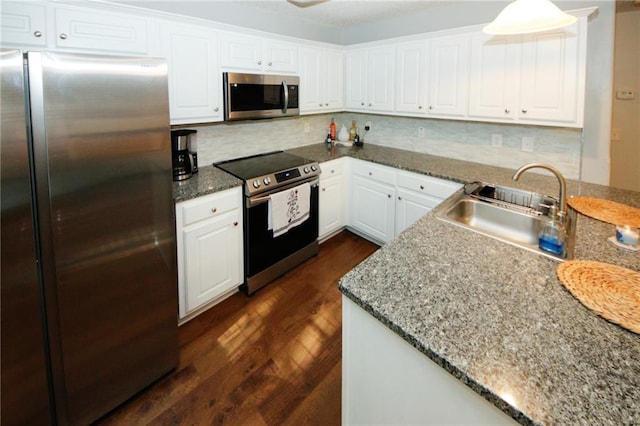 kitchen with sink, dark wood-type flooring, stone counters, stainless steel appliances, and white cabinets