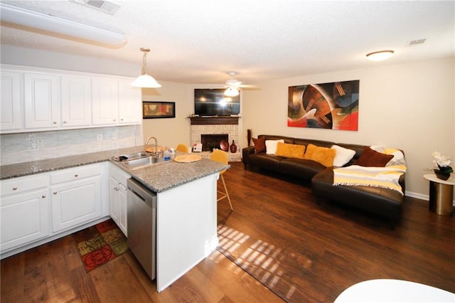 kitchen with white cabinetry, dishwasher, hanging light fixtures, kitchen peninsula, and light stone countertops