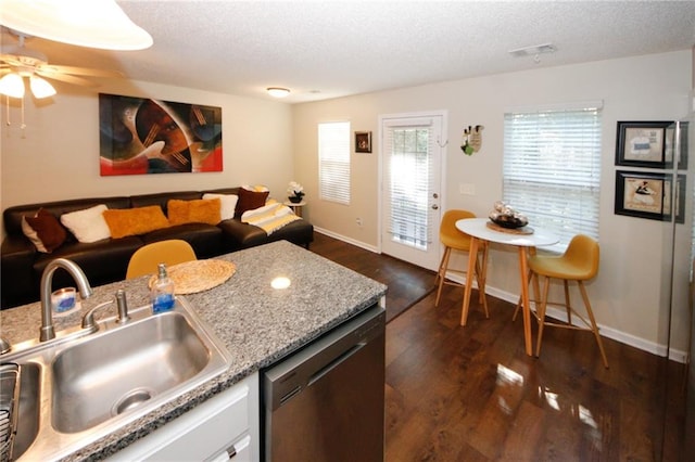 kitchen with black dishwasher, sink, a textured ceiling, and dark wood-type flooring