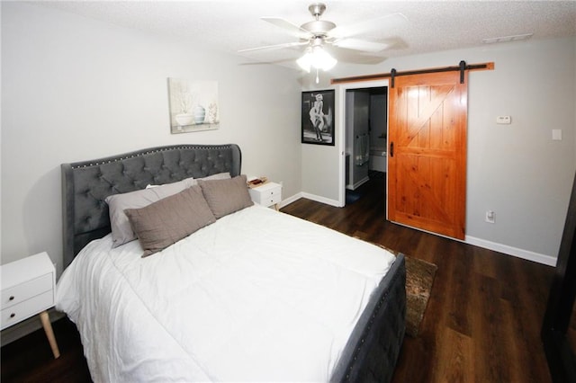 bedroom with a barn door, dark hardwood / wood-style floors, and ceiling fan