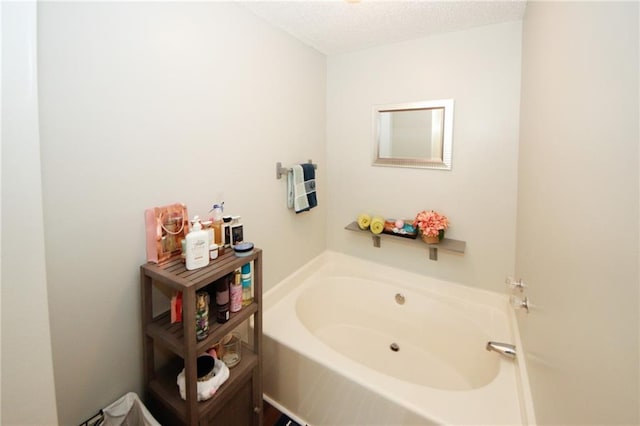 bathroom with a bathing tub and a textured ceiling