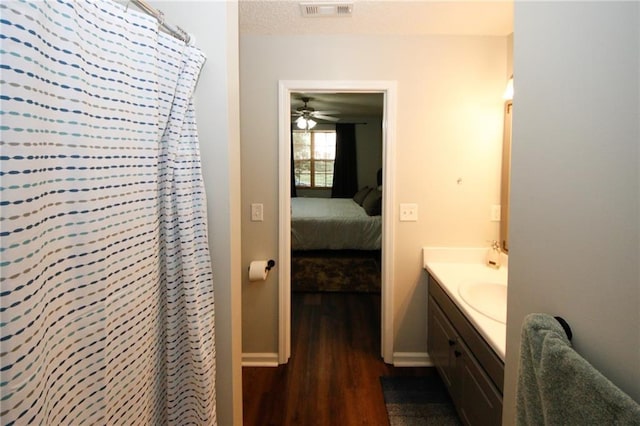 bathroom with vanity, wood-type flooring, a textured ceiling, and a shower with shower curtain