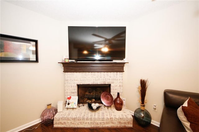 sitting room featuring dark hardwood / wood-style flooring and a brick fireplace