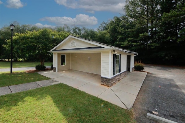 view of side of home with a yard and a carport