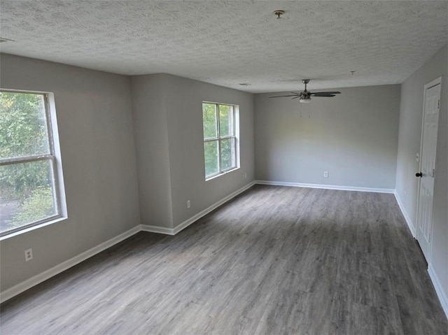 unfurnished room featuring dark hardwood / wood-style floors, ceiling fan, and a textured ceiling