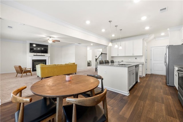 dining room featuring sink, crown molding, dark hardwood / wood-style floors, and ceiling fan