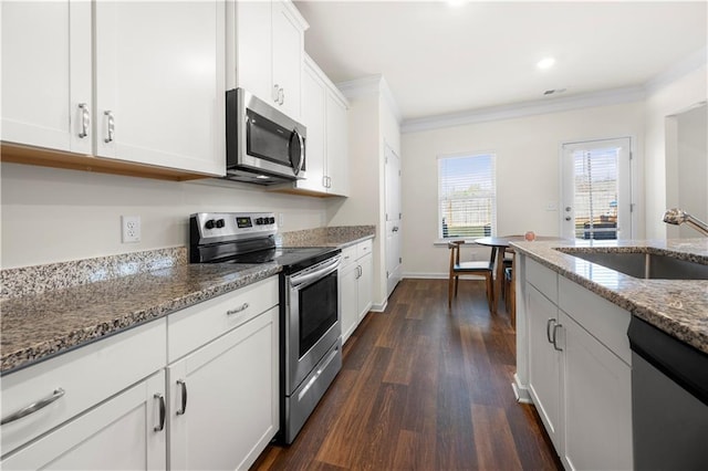 kitchen with light stone counters, sink, white cabinets, and appliances with stainless steel finishes