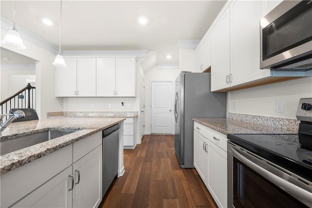 kitchen with pendant lighting, white cabinetry, dark hardwood / wood-style flooring, ornamental molding, and stainless steel appliances