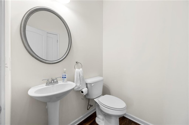 bathroom featuring wood-type flooring, sink, and toilet