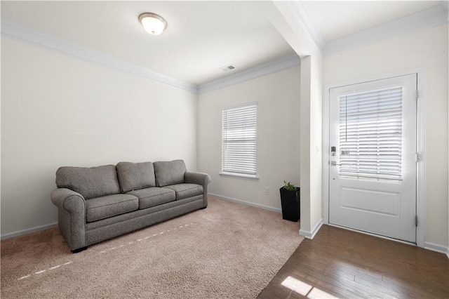 living room featuring a healthy amount of sunlight, ornamental molding, and hardwood / wood-style floors