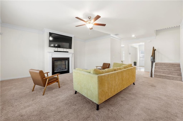 living room with ceiling fan, ornamental molding, and light carpet