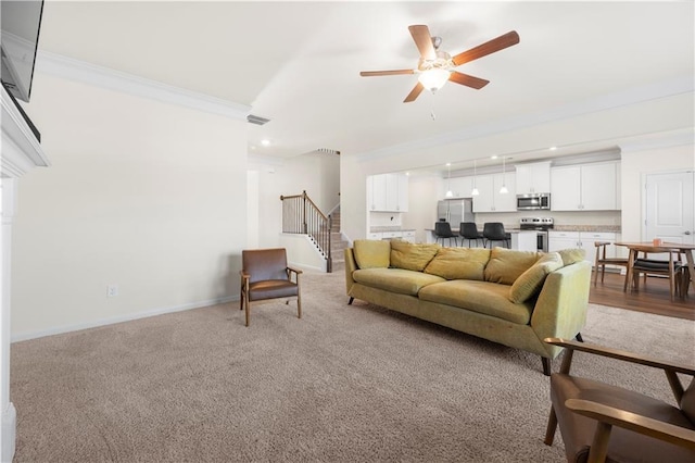 carpeted living room with crown molding and ceiling fan