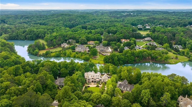 birds eye view of property featuring a water view and a view of trees