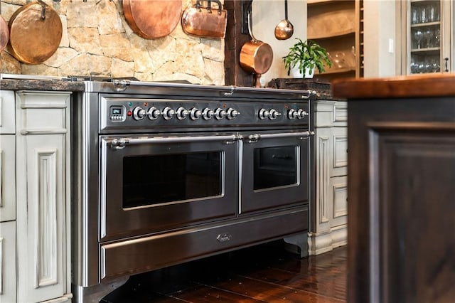 kitchen featuring dark countertops, double oven range, and dark wood finished floors