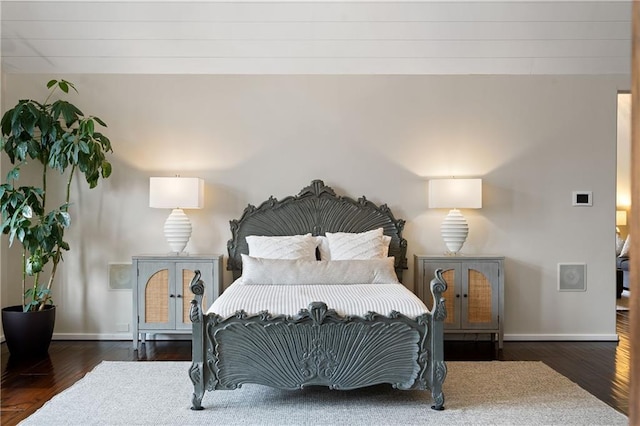 bedroom featuring dark wood-style flooring and baseboards