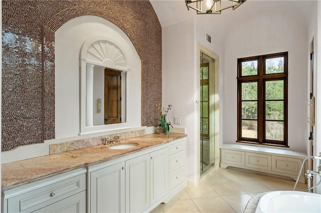 bathroom featuring a stall shower, visible vents, tile patterned floors, vanity, and a chandelier